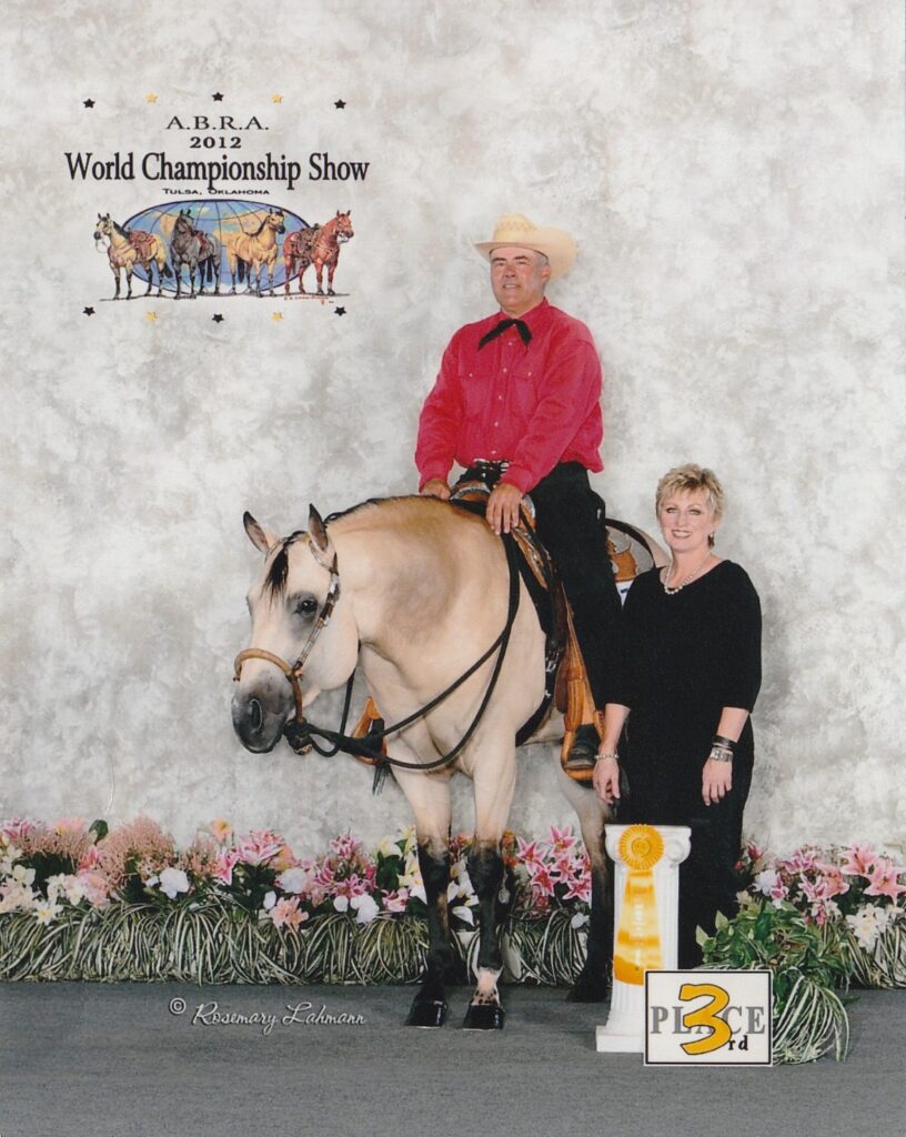 A man and woman standing next to a horse.